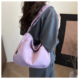 Pale purple nylon tote bag with wide adjustable shoulder strap worn by a model