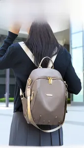 Photo de mode en extérieur d'un sac à dos en nylon beige avec rivets étoiles dorés