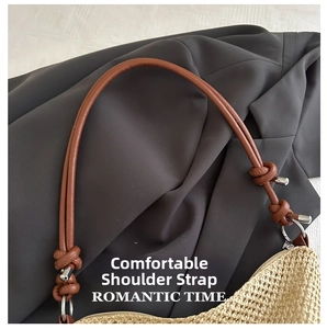 Dettaglio borsa di paglia beige con tracolla in pelle marrone e nodo decorativo in metallo