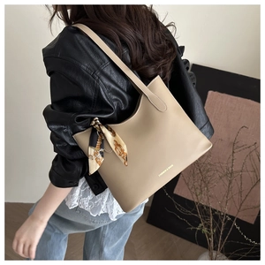 Détail du cabas beige avec foulard en soie imprimé sur la bandoulière et logo