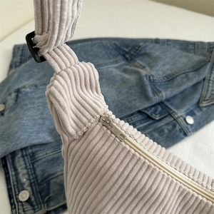 Minimalist corduroy hobo bag in cream with texture detail and adjustable strap