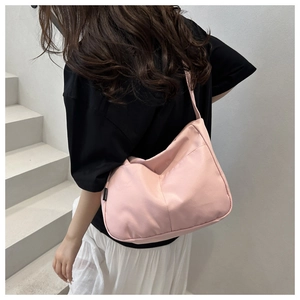 Detailed side view of pink nylon hobo bag with adjustable strap on a model