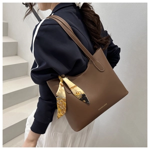 Sac cabas marron en similicuir avec foulard en soie et surpiqûres blanches sur mannequin