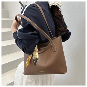 Sac cabas en cuir marron avec foulard vintage porté par un mannequin en ville