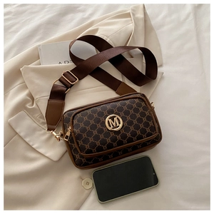Detailed view of vintage brown monogram crossbody bag with golden M logo and wide strap