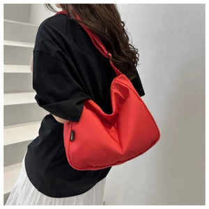 Detailed view of red waterproof cloud bag with adjustable strap and side brand label