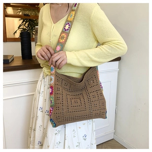 Close-up of bohemian hollow crochet shoulder bag with colorful floral knit straps