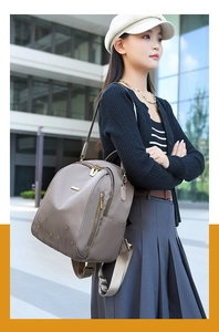 Détail du sac à dos taupe en tissu Oxford avec clous étoilés et poche latérale utile