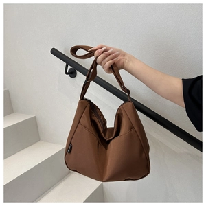 Detail of a brown hobo shoulder bag with black adjustable strap and smooth nylon texture