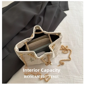 Internal capacity of lace straw bucket bag showing phone, wallet and earphones inside