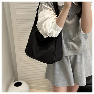 Detail of black large capacity tote bag with adjustable strap and side pocket