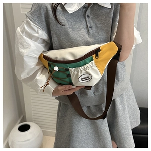 Détail du sac de poitrine bicolore en nylon avec panneaux vert forêt, blanc et jaune