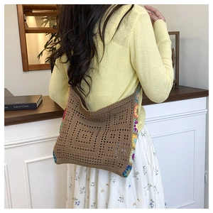 Detail of a brown crochet shoulder bag with colorful bohemian knit trim on the side