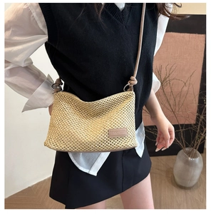Dettaglio della trama intrecciata beige e dell'etichetta in pelle rosa della borsa