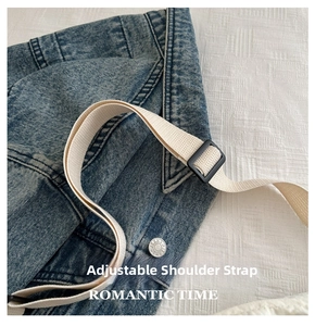 Detail of adjustable beige fabric strap and plastic buckle on blue denim gym bag