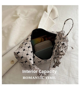 Internal view of plaid shoulder bag with bow detail showing spacious storage capacity