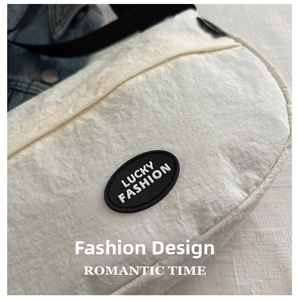 Close-up of off-white crinkled texture bag with lucky fashion logo and black rubber patch