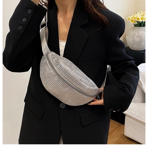 Gros plan d'un sac banane argenté à strass porté en bandoulière avec décor floral élégant