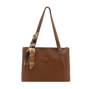 Brown faux leather tote bag with white contrast stitching and decorative scarf