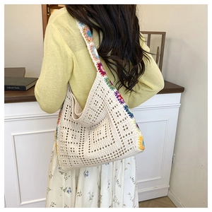 Close-up of cream crochet tote bag featuring colorful 3D floral strap details