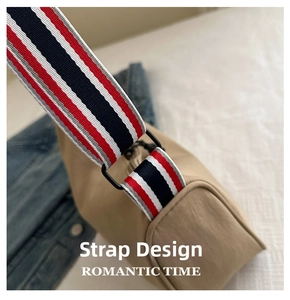 Détail de la large bandoulière à rayures colorées et boucle en métal du sac fourre-tout