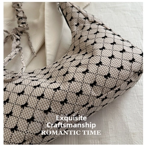Close-up of vintage check pattern fabric and bow print on large shoulder bag