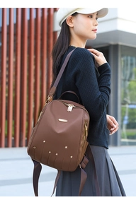 Sac à dos en tissu Oxford marron avec clous en métal étoilé et poches sur un modèle