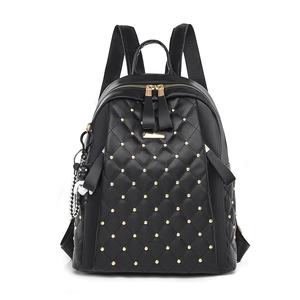 Quilted black PU leather backpack with gold rivets, handle, and a bear charm pendant