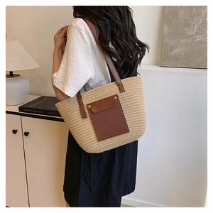 Detail showing beige woven tote bag with brown leather pocket and gold rivet accents