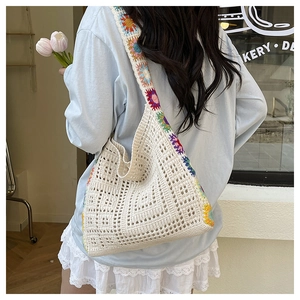 Detail of crochet tote bag featuring rainbow daisy flower straps and mesh knit texture