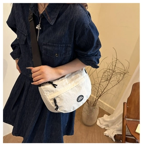 Close-up of white nylon crescent bag with adjustable strap and Lucky Fashion logo