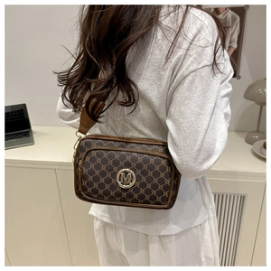 Dettaglio posteriore di una modella con borsa a tracolla marrone monogramma e tracolla larga