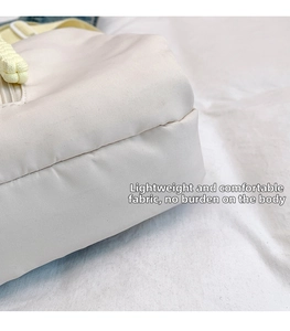 Close-up detail of soft cream canvas fabric and high-quality stitching on minimalist bag