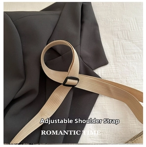 Detail view of adjustable beige woven shoulder strap with black buckle on a modern bag