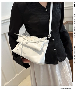 Close-up of stylish white bow tote bag with Fashion & Bags lettering and slim shoulder strap
