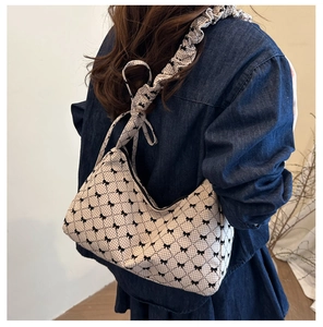 Detailed view of beige plaid shoulder bag with bow prints and ruffled strap on a model