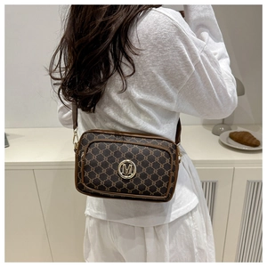 Detailed back view of vintage brown monogram crossbody bag with metallic M logo detail