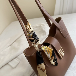 Deep brown matte leather tote bag with stylish silk scarf and gold geometric buckle