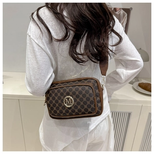 Detail of retro brown crossbody bag with gold M-logo buckle and monogram pattern