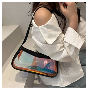 Iridescent laser PVC baguette bag with black leather trim shown on shoulder of a model