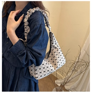 Detail of hobo bag with bow print, gingham pattern and ruffled cloud shoulder strap