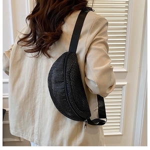 Détail d'un sac ceinture noir à strass porté avec un blazer beige pour un look d'été chic