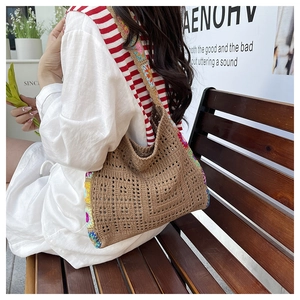 Detail of bohemian hollow crochet bag with colorful floral embroidery on coffee base