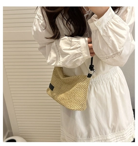 Detailed view of casual straw woven shoulder bag on model with delicate lace dress