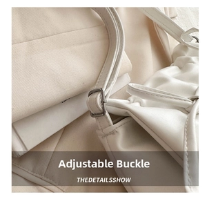 Detail of adjustable silver buckle on white PU leather shoulder bag with pleated texture