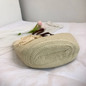 French straw tote bag with brown leather handles and lace bow for beach or commute