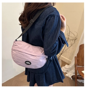 Detailed view of light purple crescent bag with nylon texture and black Lucky Fashion label