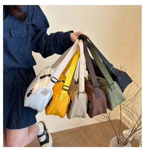 Close-up of multiple canvas bags in various colors with adjustable wide shoulder straps