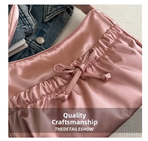 Gros plan d'un sac en satin rose avec détails plissés et un nœud décoratif chic
