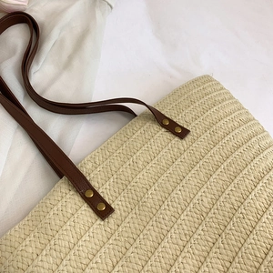 French style straw tote bag with cream woven texture and brown leather shoulder straps